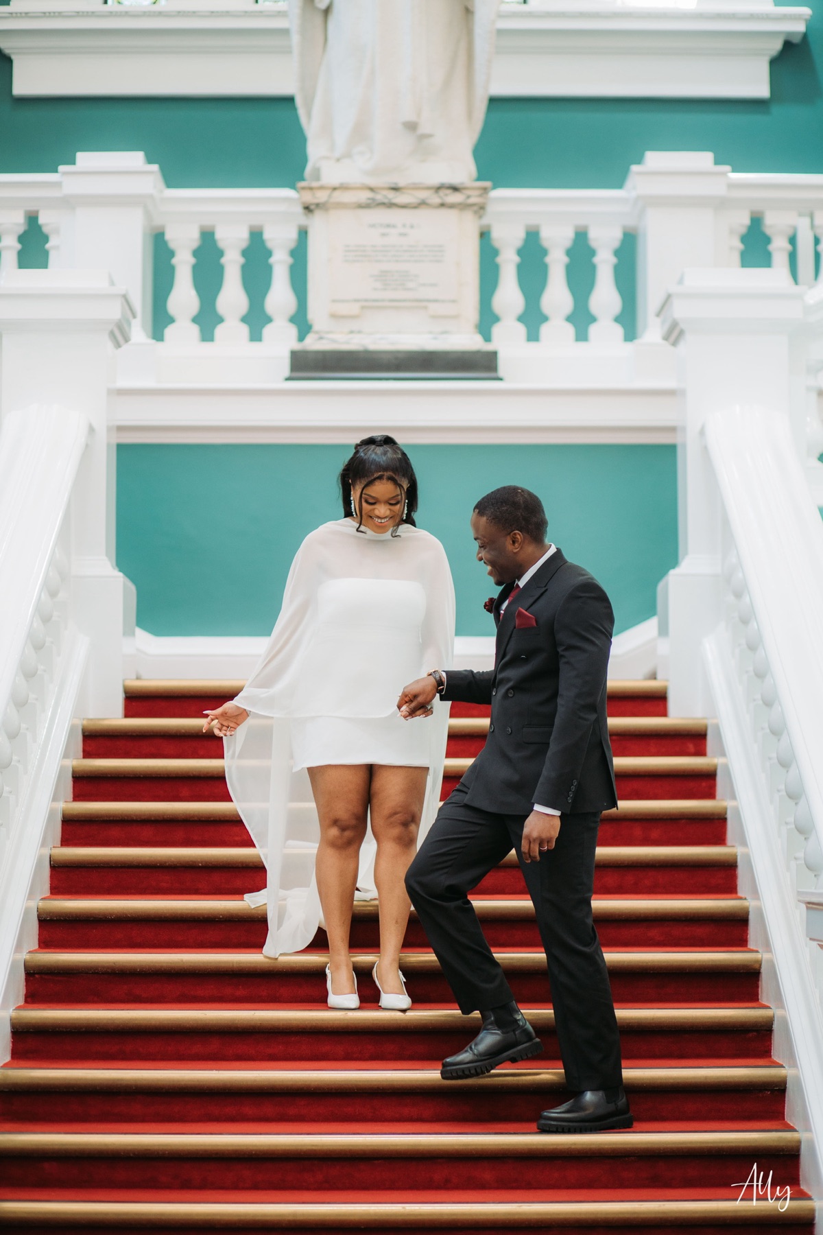 Mercy and Ifeoluwa on the red-carpeted staircase